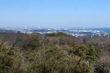 横浜の街並みの先に霞む都心のビル群